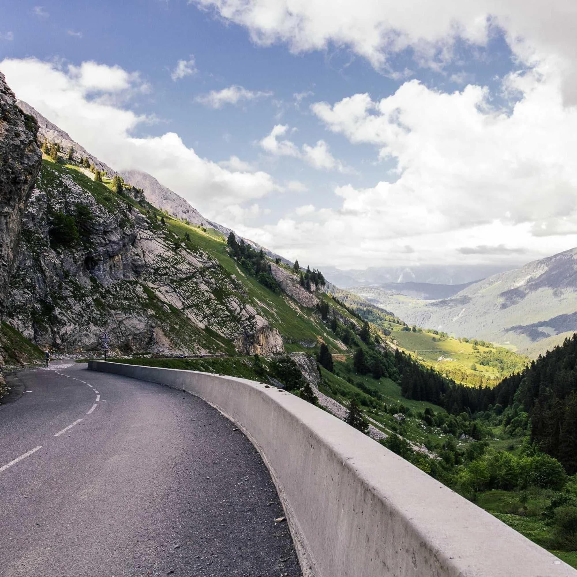 Route de montagne taillée dans la roche, vallée en contrebas
