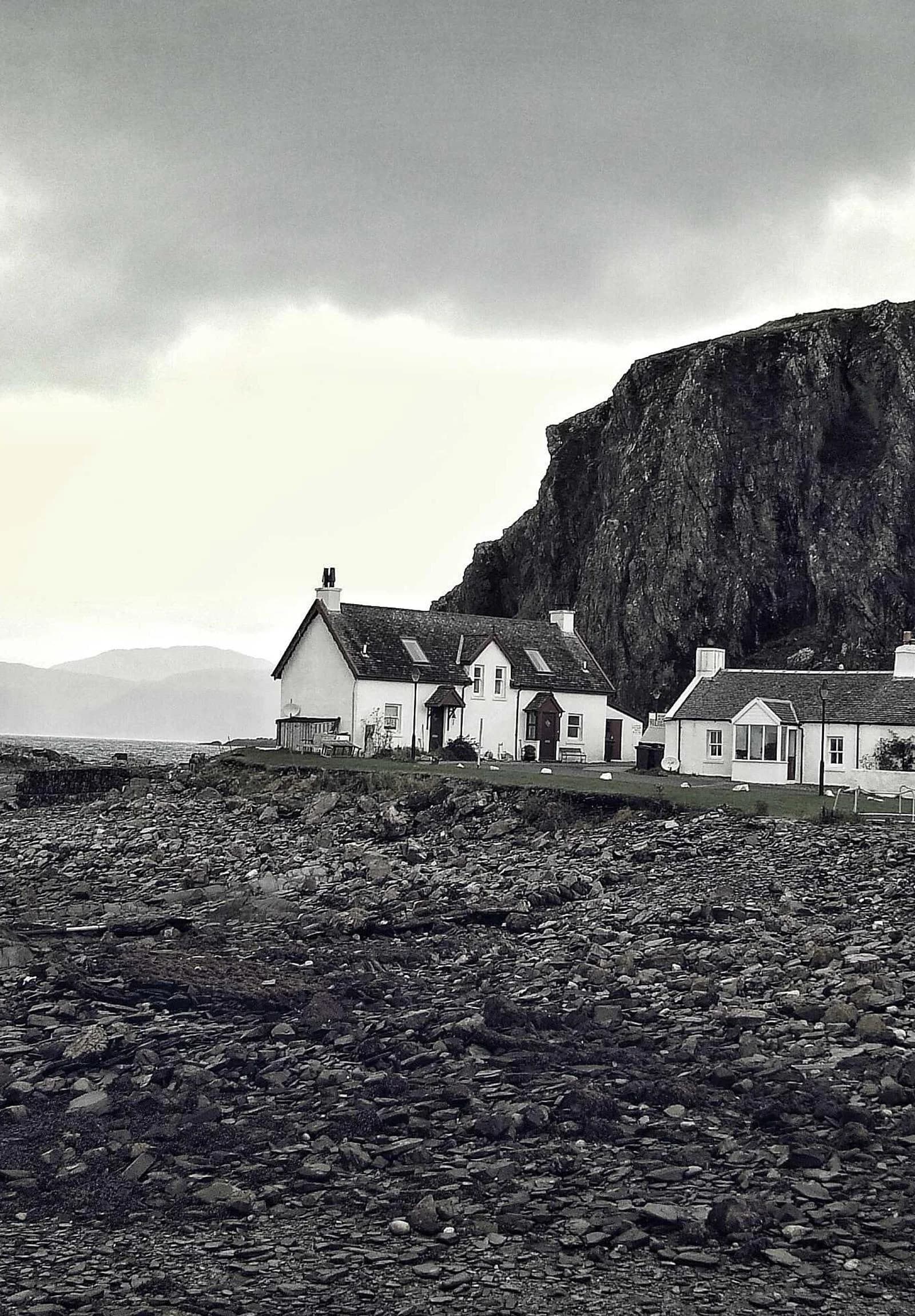 Maisons blanches au pied d’une falaise noire